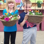 Photo of two children holding planters they made